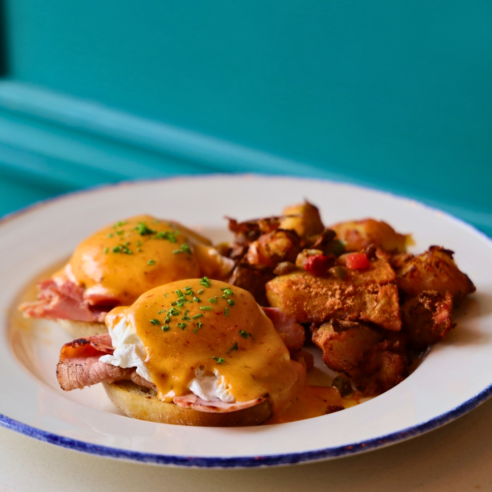 Eggs Benedict | Ham, English Muffin, Morita Infused Hollandaise Sauce, served with Sabór Breakfast Potatoes